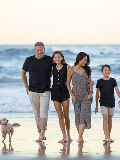 Family walking on the beach with their dog